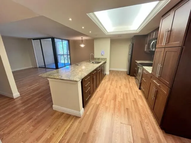 a view of kitchen with sink and refrigerator