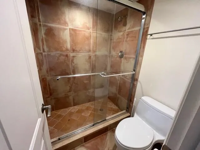 a bathroom with a toilet and a shower