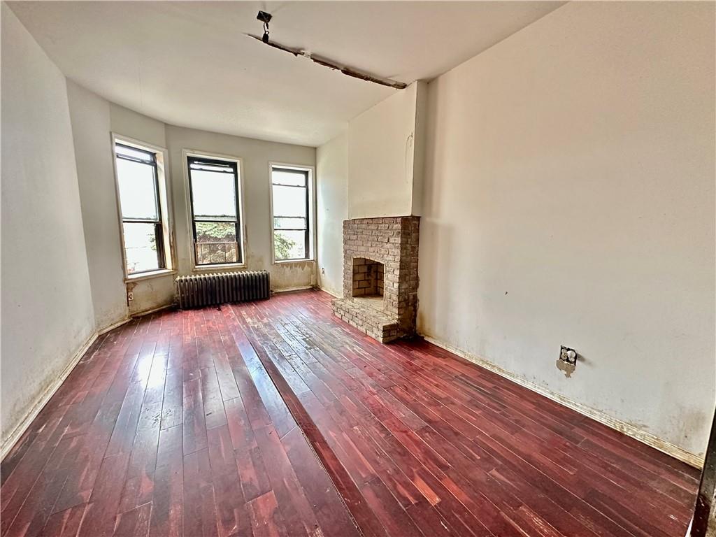 868 55th Street Brooklyn, NY 11220 - Photo 3 of 9 a view of empty room with wooden floor and fan