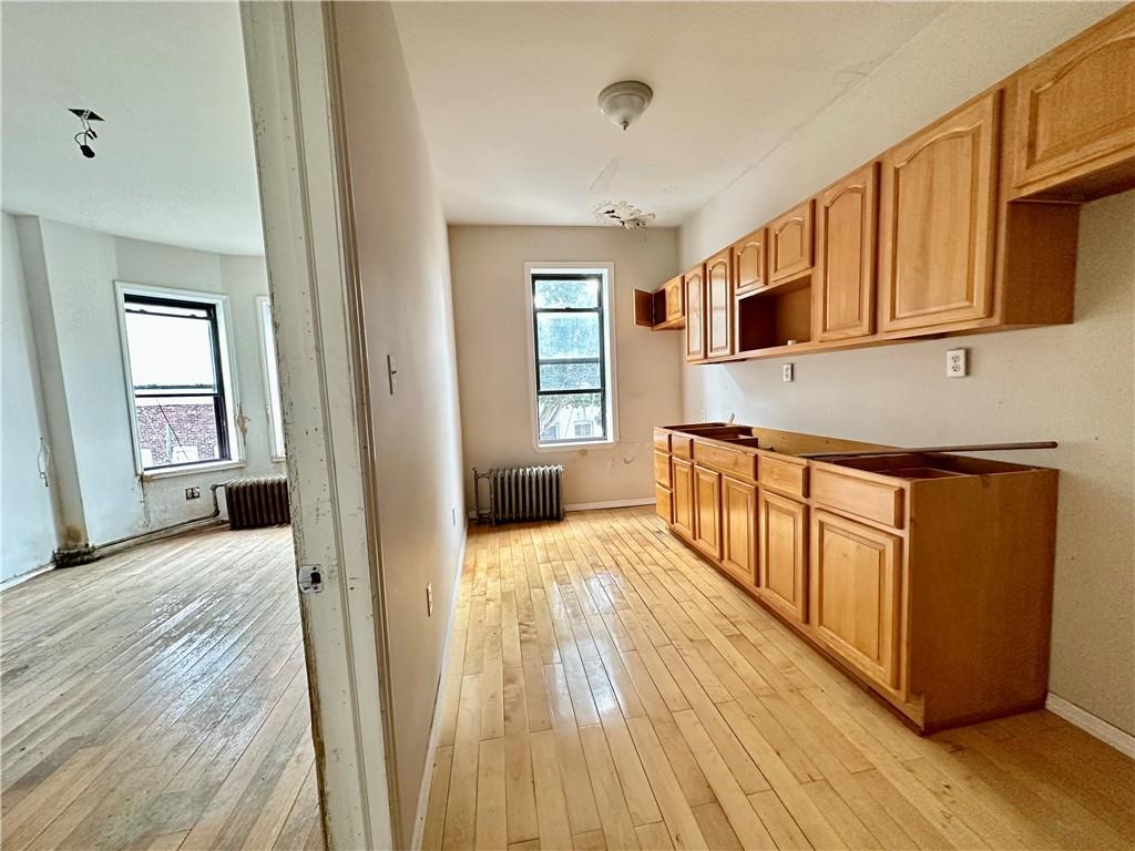 868 55th Street Brooklyn, NY 11220 - Photo 4 of 9 a view of a kitchen with wooden floor and electronic appliances