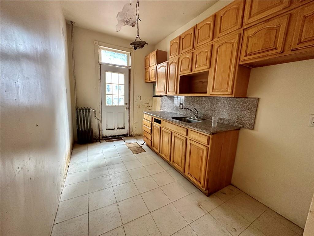 868 55th Street Brooklyn, NY 11220 - Photo 5 of 9 a kitchen with stainless steel appliances granite countertop a sink and cabinets
