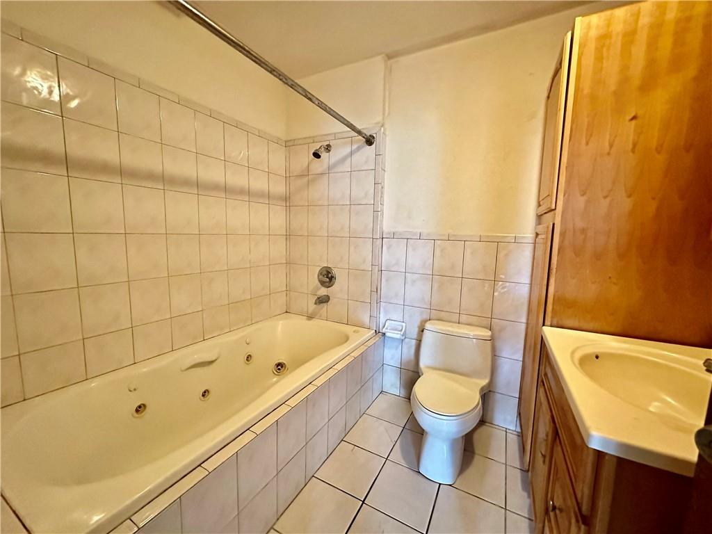 868 55th Street Brooklyn, NY 11220 - Photo 6 of 9 a bathroom with a bathtub and toilet