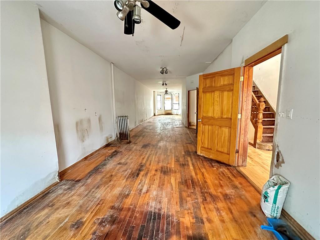 868 55th Street Brooklyn, NY 11220 - Photo 7 of 9 a view of an empty room with wooden floor and a window