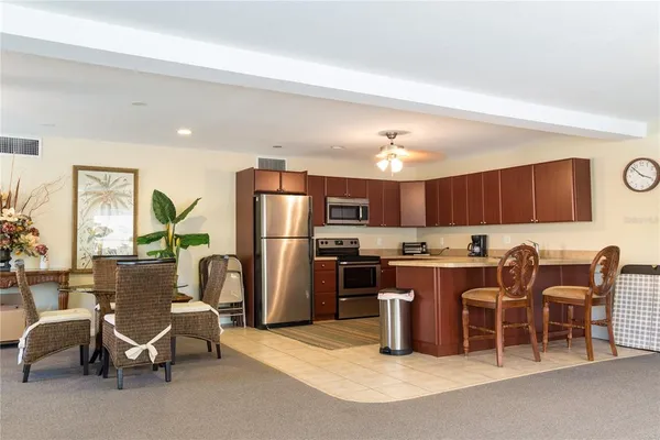 a kitchen with a refrigerator a table and chairs in it