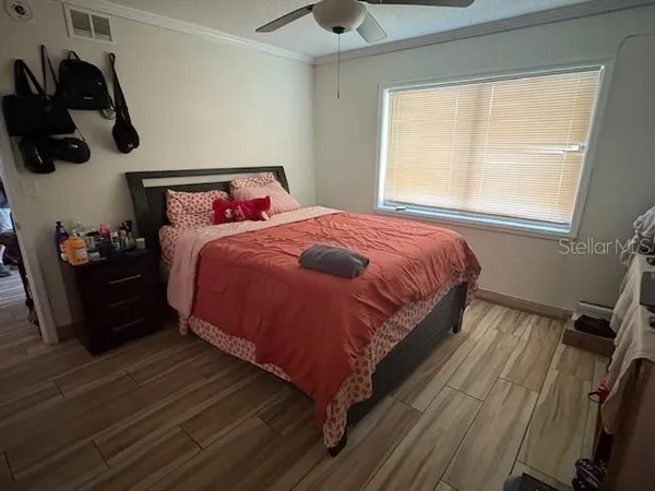a bedroom with a bed and wooden floor