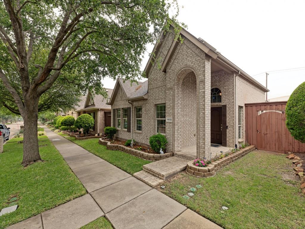 10032 Bell Rock Road Frisco, TX 75035 - Photo 2 of 23 Brick exterior with an arched entryway, mature front yard tree, sidewalk entry, manicured landscaping, and a side gate.