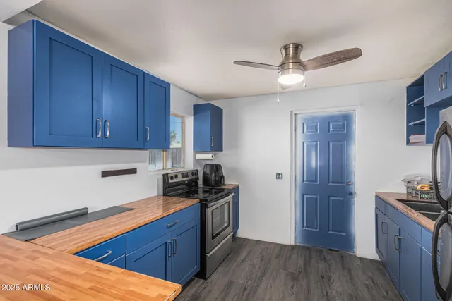 a kitchen with stainless steel appliances granite countertop a sink cabinets and wooden floor