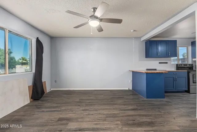 a view of kitchen with granite countertop cabinets and flat screen tv