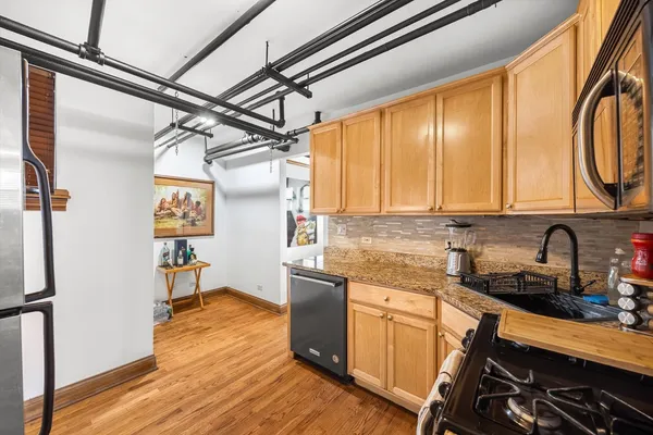 a kitchen with a sink a refrigerator and cabinets
