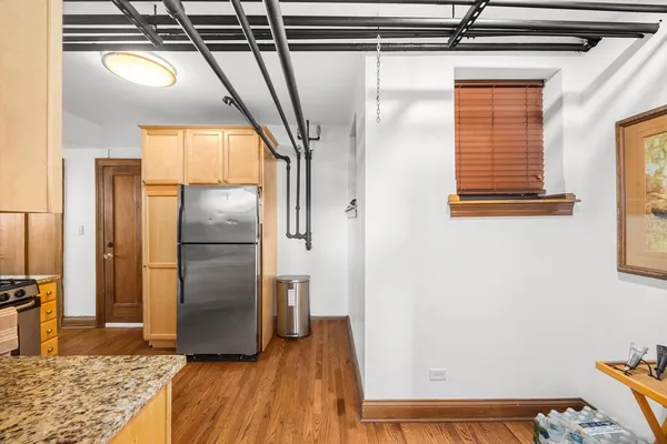 a view of a refrigerator in kitchen and wooden floor