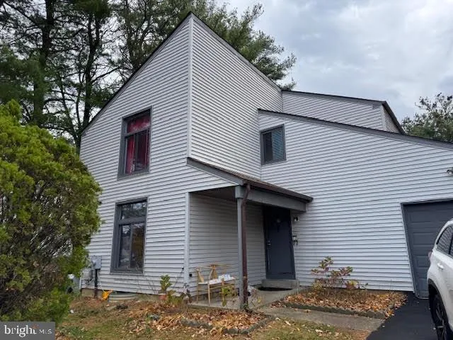 a front view of a house with a tree