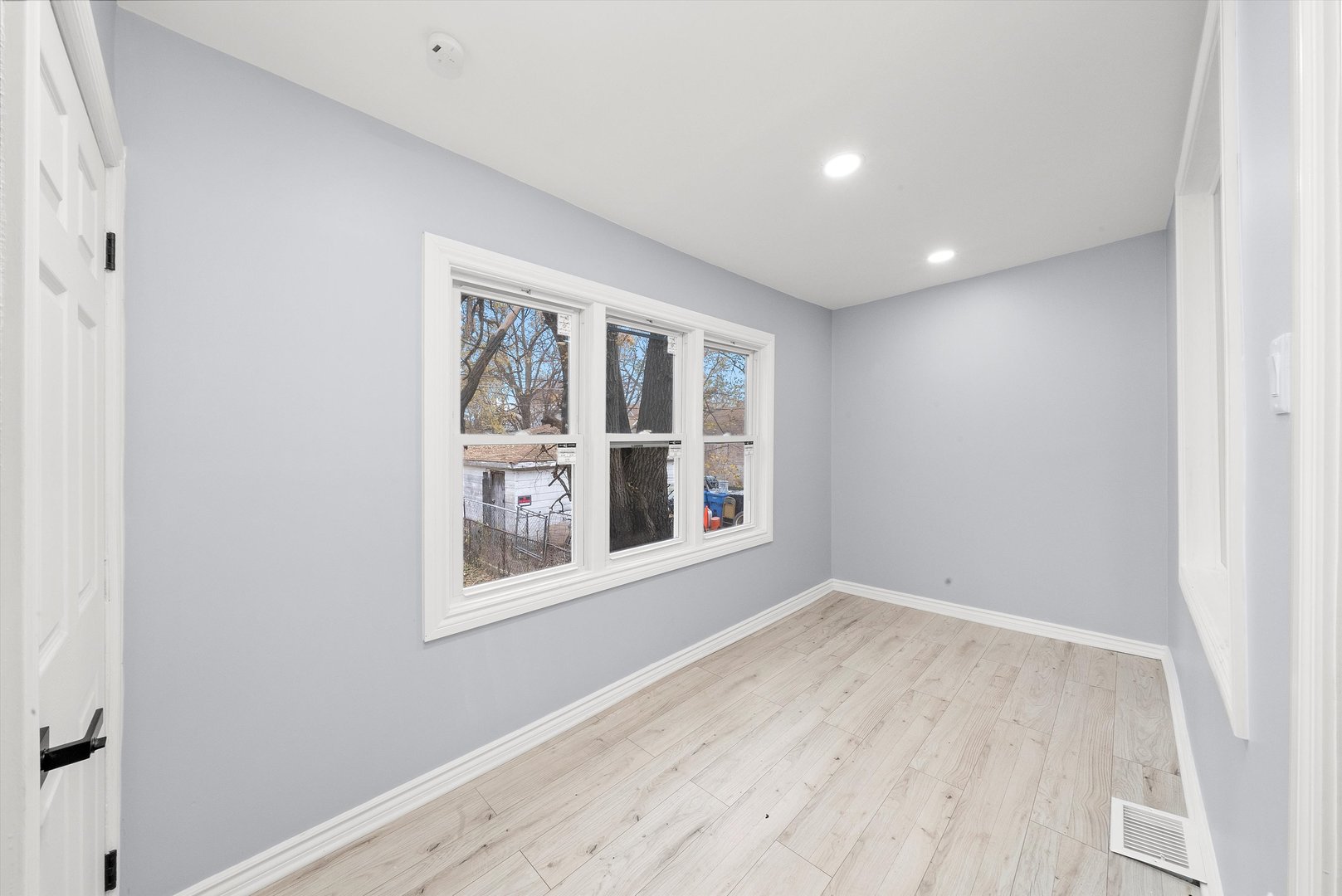 11730 South Perry Avenue Chicago, IL 60628 - Photo 16 of 25 an empty room with wooden floor and windows
