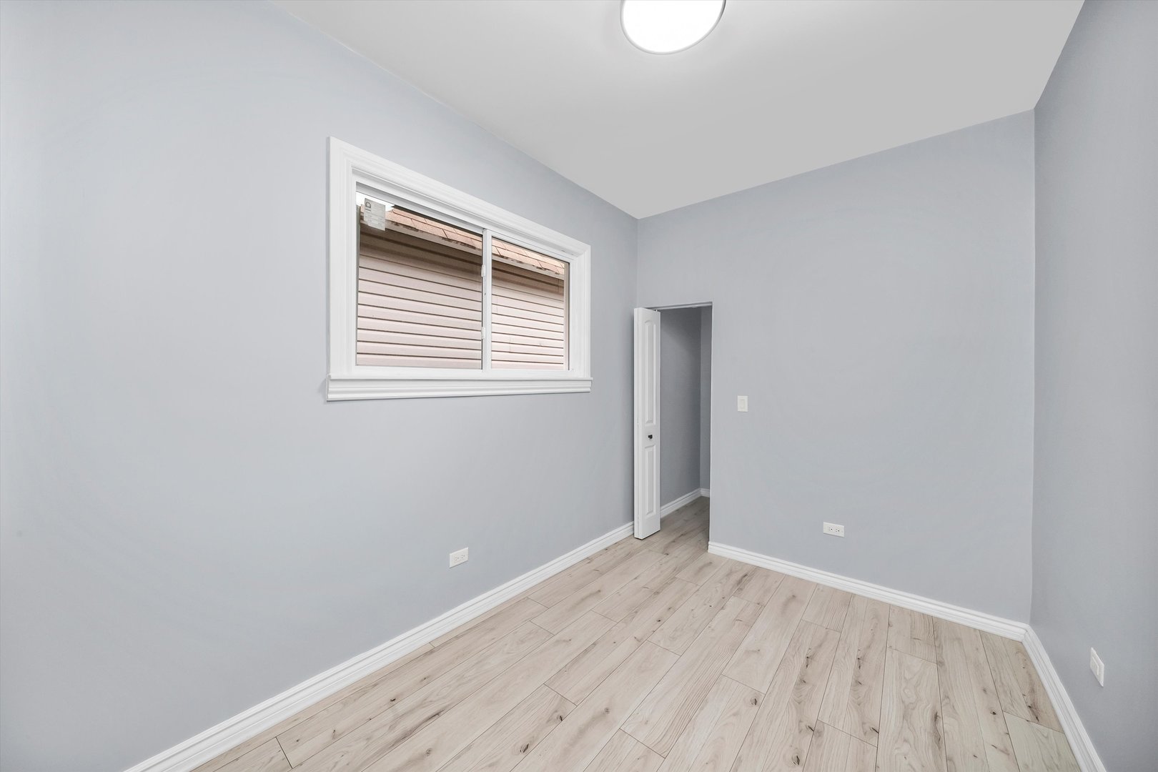 11730 South Perry Avenue Chicago, IL 60628 - Photo 7 of 25 a view of an empty room with wooden floor and a window