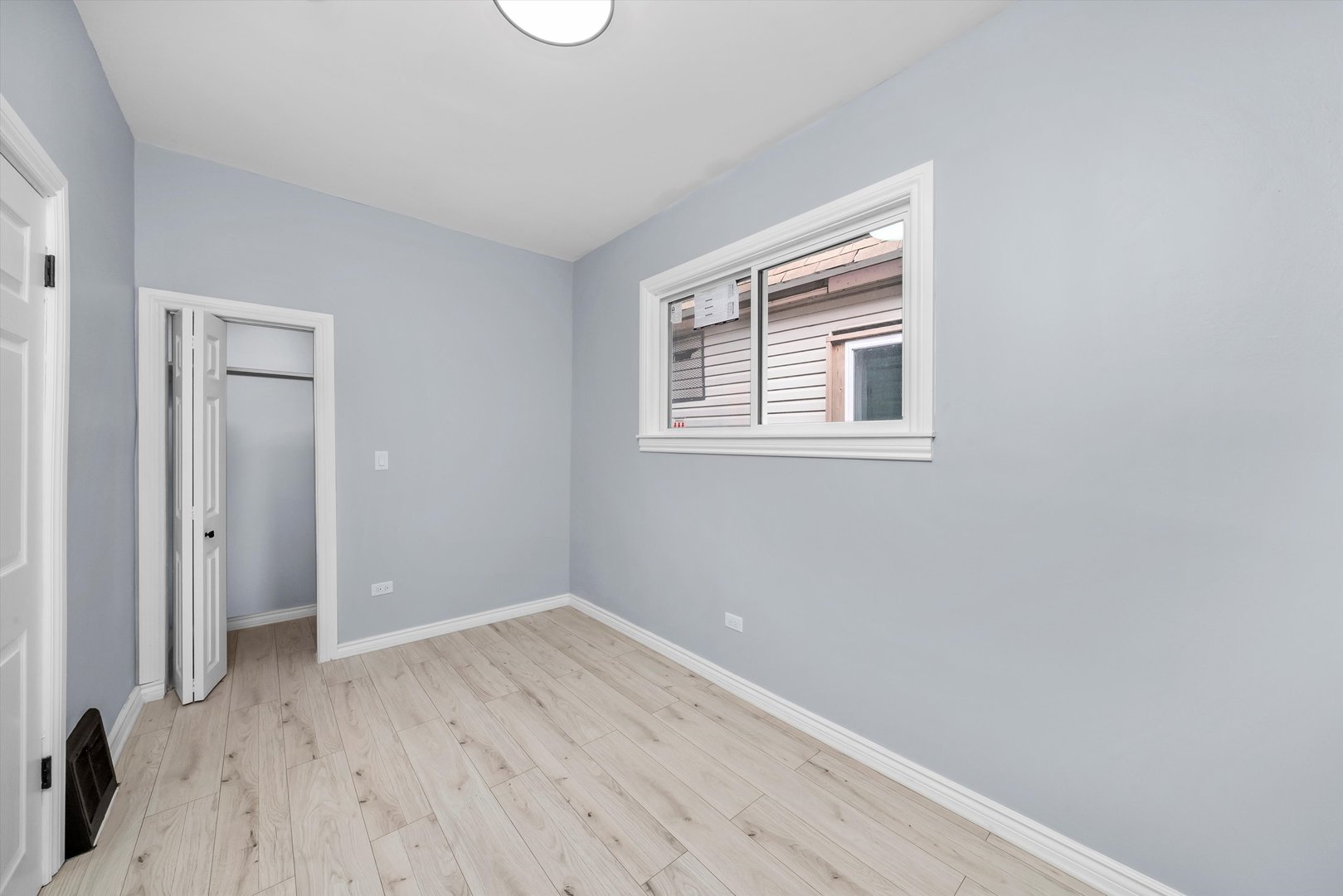 11730 South Perry Avenue Chicago, IL 60628 - Photo 10 of 25 a view of an empty room with wooden floor and a window
