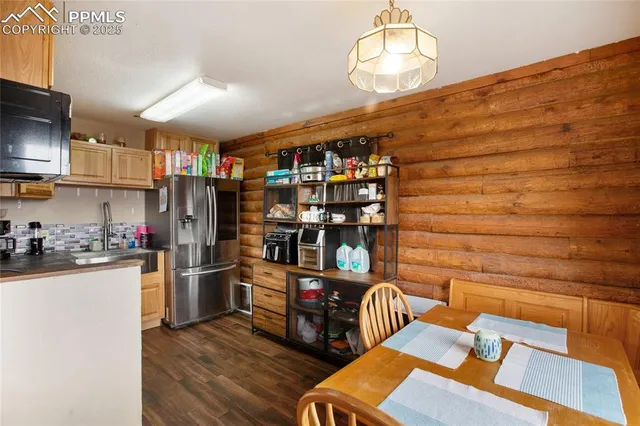 a kitchen with stainless steel appliances a refrigerator and a wooden floor