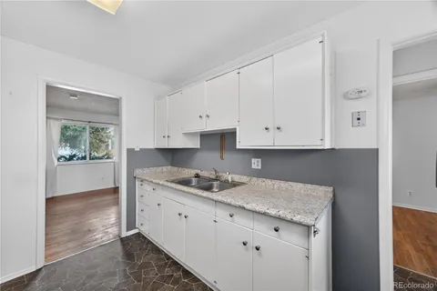 a kitchen with granite countertop a sink stove and cabinets
