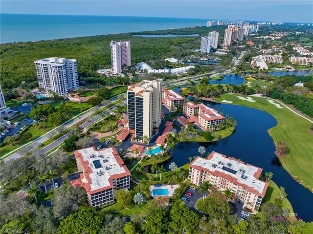 aerial view of a city with lots of residential buildings ocean and mountain view in back