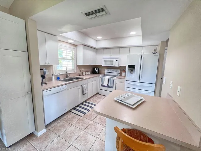 a kitchen with stainless steel appliances granite countertop a refrigerator sink and stove