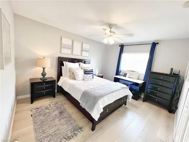 a bedroom with a bed and dresser with mirror