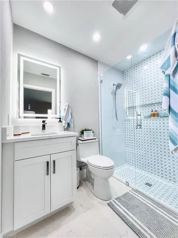 a bathroom with a toilet sink double vanity and mirror