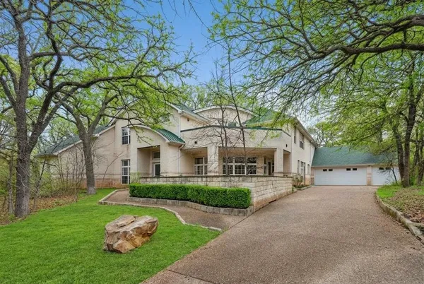 a front view of a house with a yard and trees