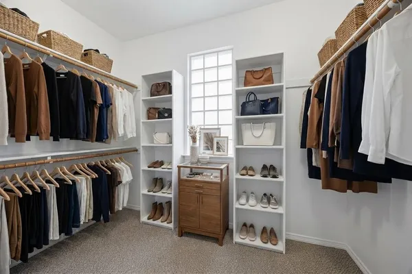 a view of walk in closet with clothes and shoes