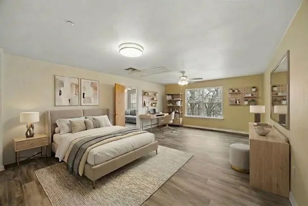 a spacious bedroom with a bed a couch and large window