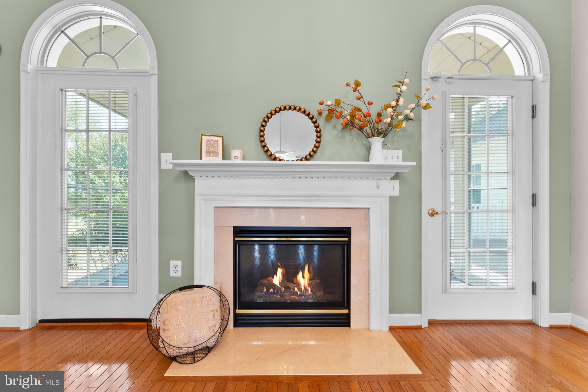 19065 Stallion Road Culpeper, VA 22701 - Photo 10 of 40 a living room with a fireplace a chandelier and a wooden floor
