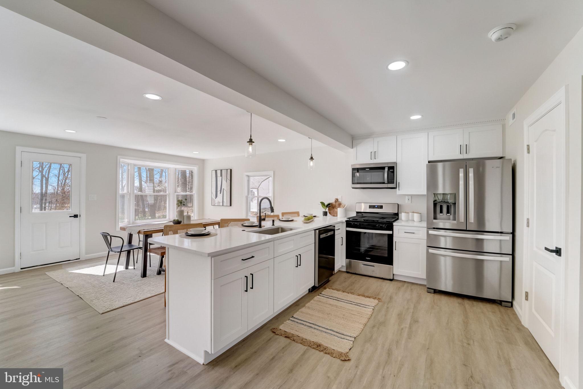 a large kitchen with a center island and stainless steel appliances