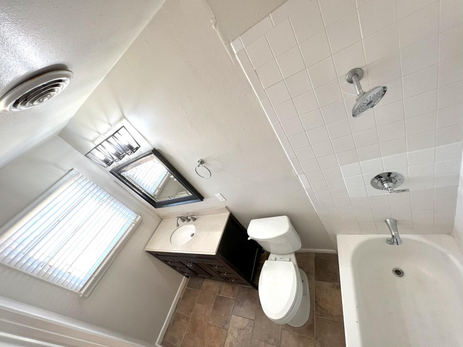 4214 54th Street Lubbock, TX 79413 - Photo 13 of 18 a bathroom with a sink mirror and vanity