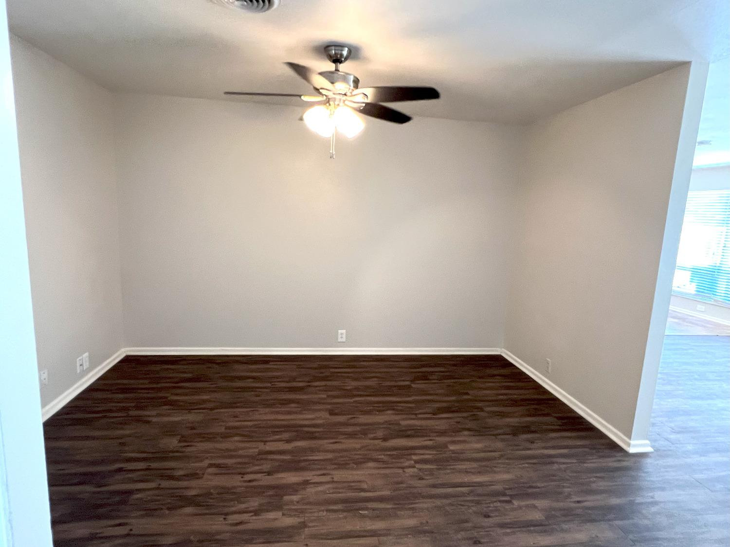 4214 54th Street Lubbock, TX 79413 - Photo 3 of 18 a view of a room with wooden floor and a ceiling fan