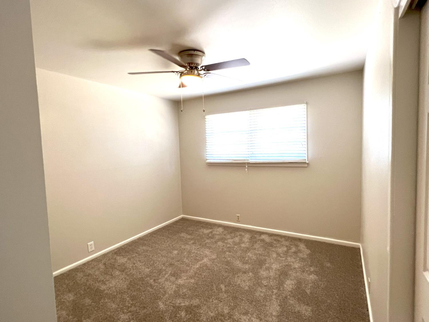 4214 54th Street Lubbock, TX 79413 - Photo 7 of 18 an empty room with a window and a fan