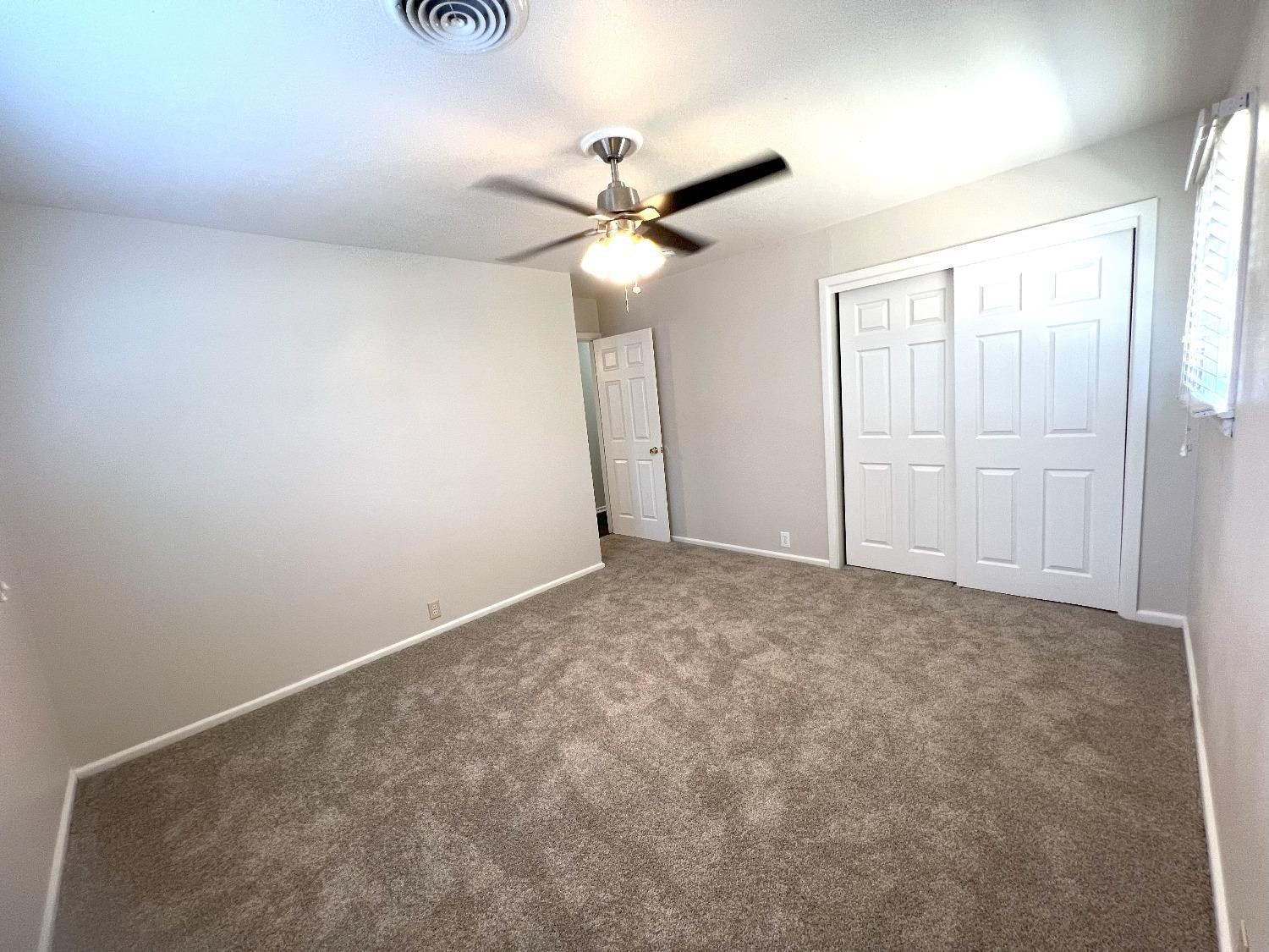 4214 54th Street Lubbock, TX 79413 - Photo 10 of 18 an empty room with a ceiling fan and a window