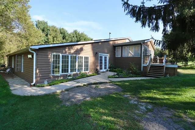 a view of backyard of house with green space