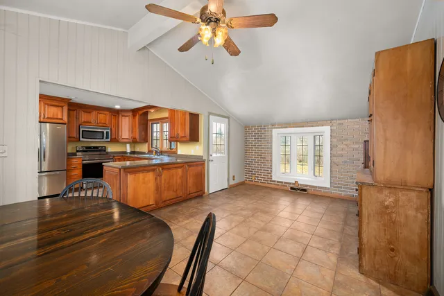 a open kitchen with stainless steel appliances granite countertop a refrigerator a stove and a sink with dishwasher
