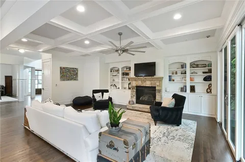 a kitchen with stainless steel appliances granite countertop a kitchen island a stove a refrigerator a dining table and chairs with wooden floor