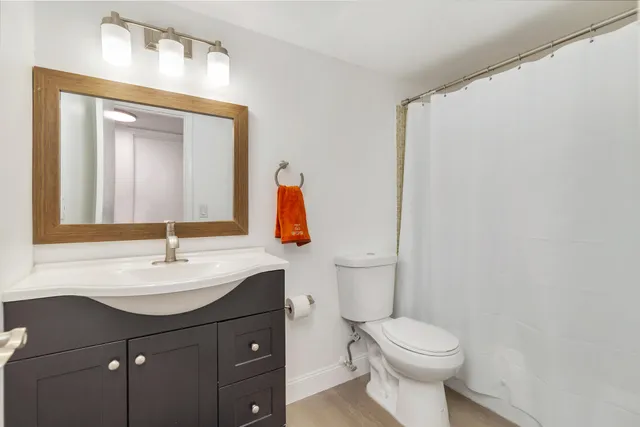a bathroom with a sink vanity mirror and toilet