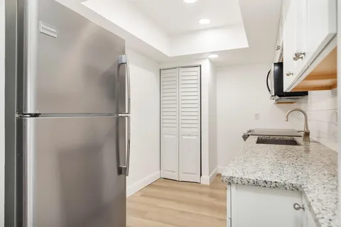 a kitchen with stainless steel appliances granite countertop a refrigerator and a sink