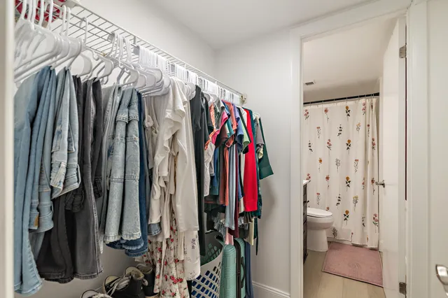 a view of walk in closet with clothes and shoes