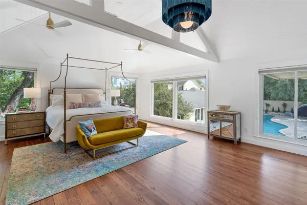 a bedroom with a bed and large windows