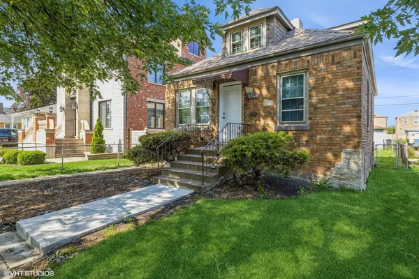 a view of a brick house with a yard and plants