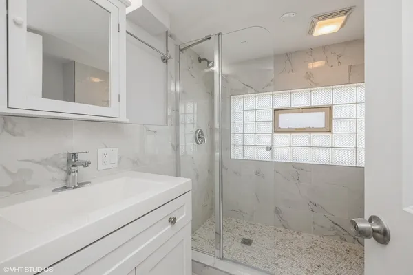 a bathroom with a shower sink and mirror
