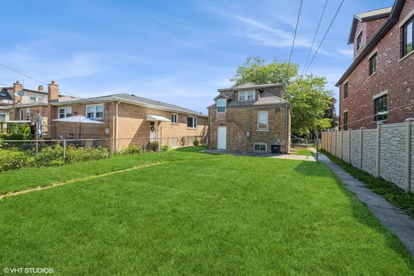 a view of a house with a big yard plants and large trees