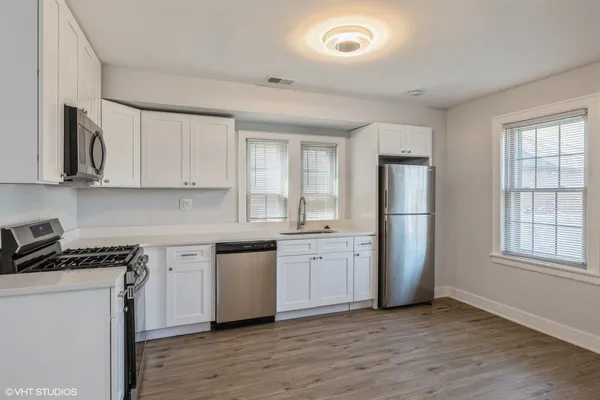 a kitchen with stainless steel appliances granite countertop a stove a sink and a refrigerator