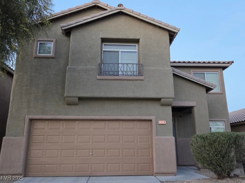 2924 Covatta Court North Las Vegas, NV 89086 - Photo 2 of 27 View of front of house featuring stucco siding, a tiled roof, an attached garage, and a balcony