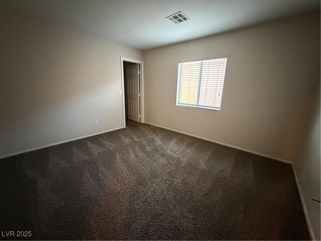 2924 Covatta Court North Las Vegas, NV 89086 - Photo 21 of 27 Spare room featuring dark colored carpet and baseboards