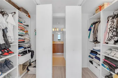 a view of walk in closet with clothes and shoes