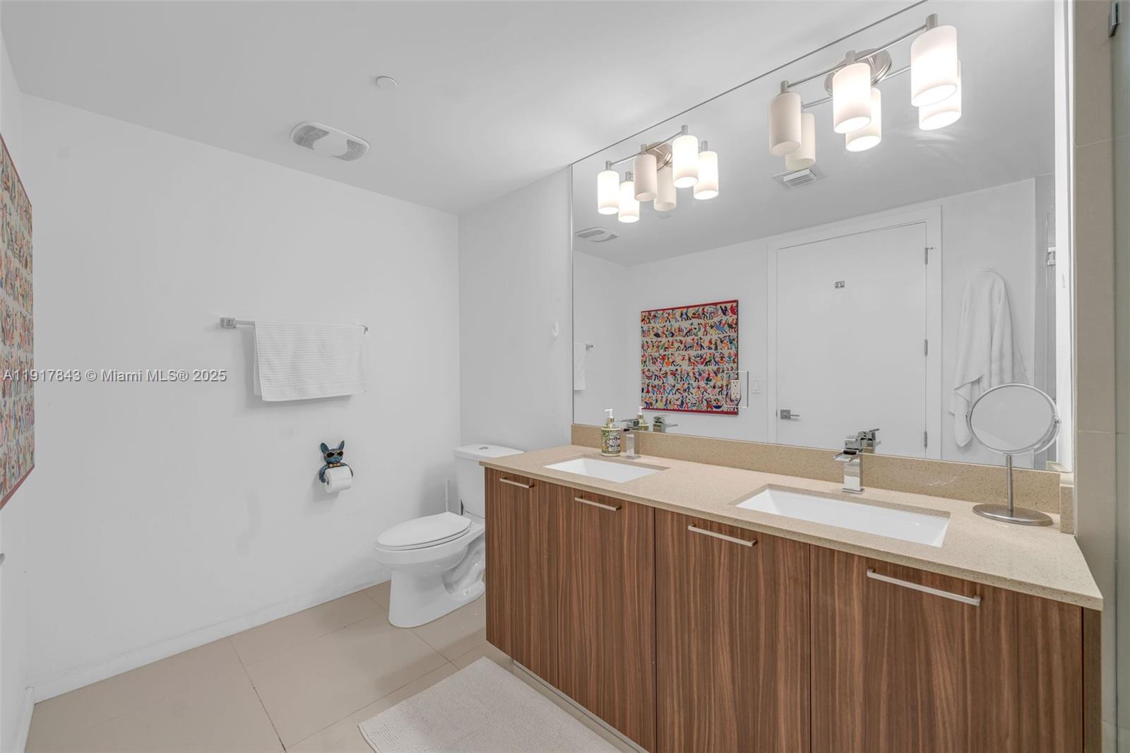 5252 Northwest 85th Avenue, Unit 504 Doral, FL 33166 - Photo 21 of 31 a bathroom with a sink a toilet a mirror and vanity