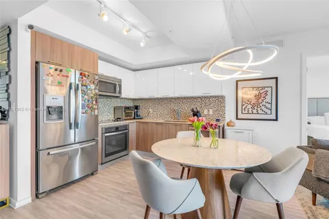 a kitchen with stainless steel appliances a dining table chairs and chandelier