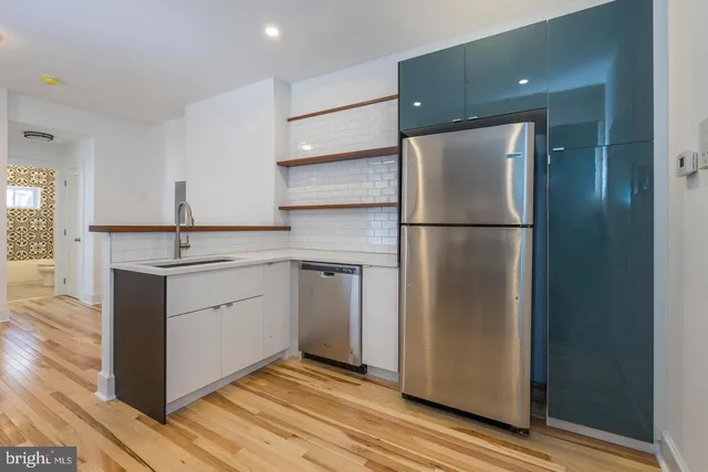 a kitchen with a sink stainless steel appliances and refrigerator